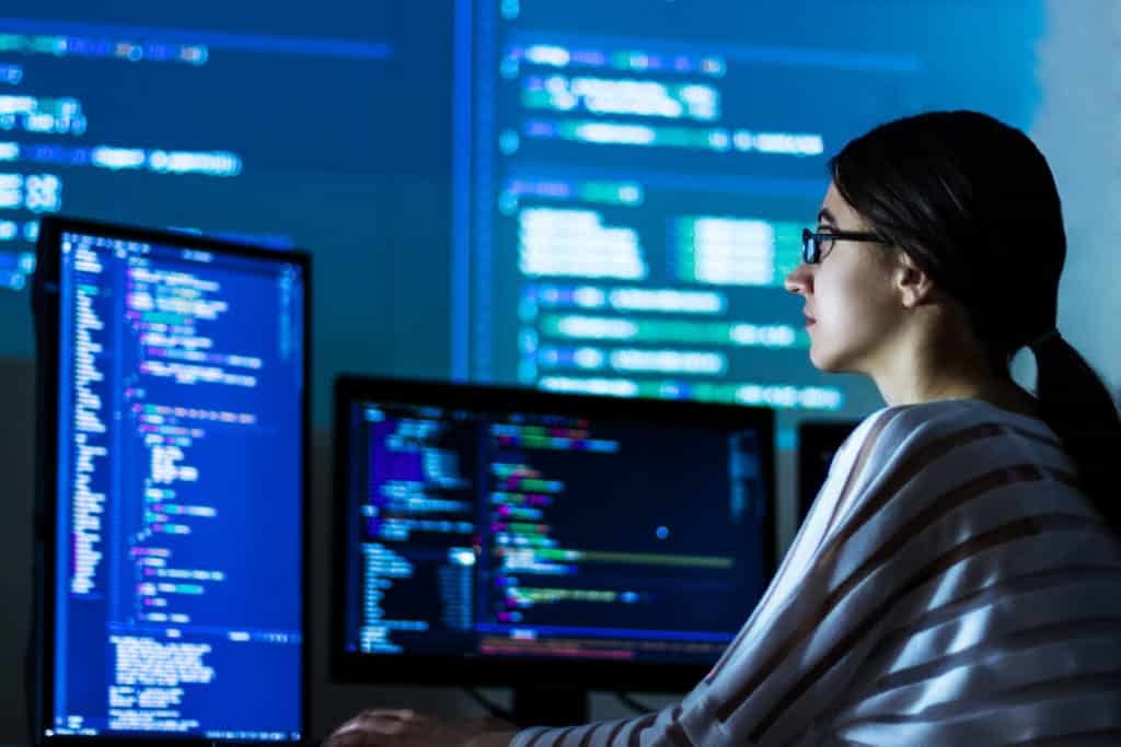 An engineer working across several screens